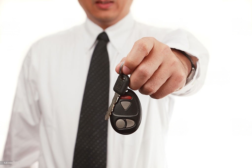 a man handing a car key