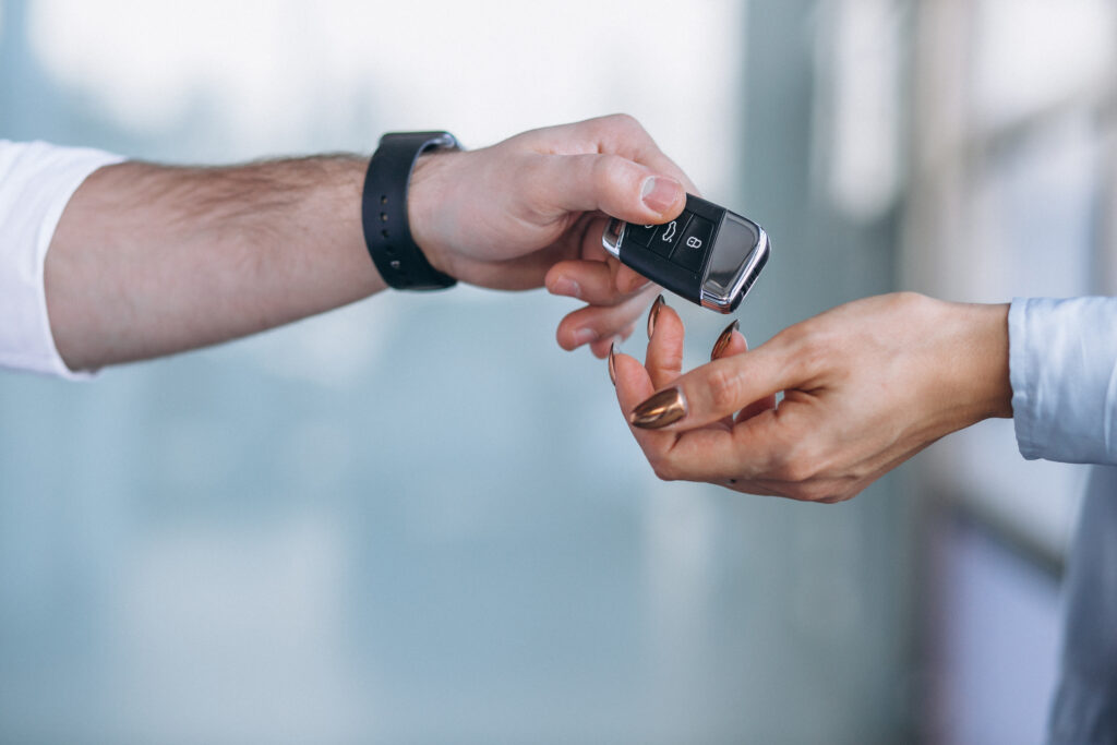 a person handing a car key to woman - car key locksmith in port stanley